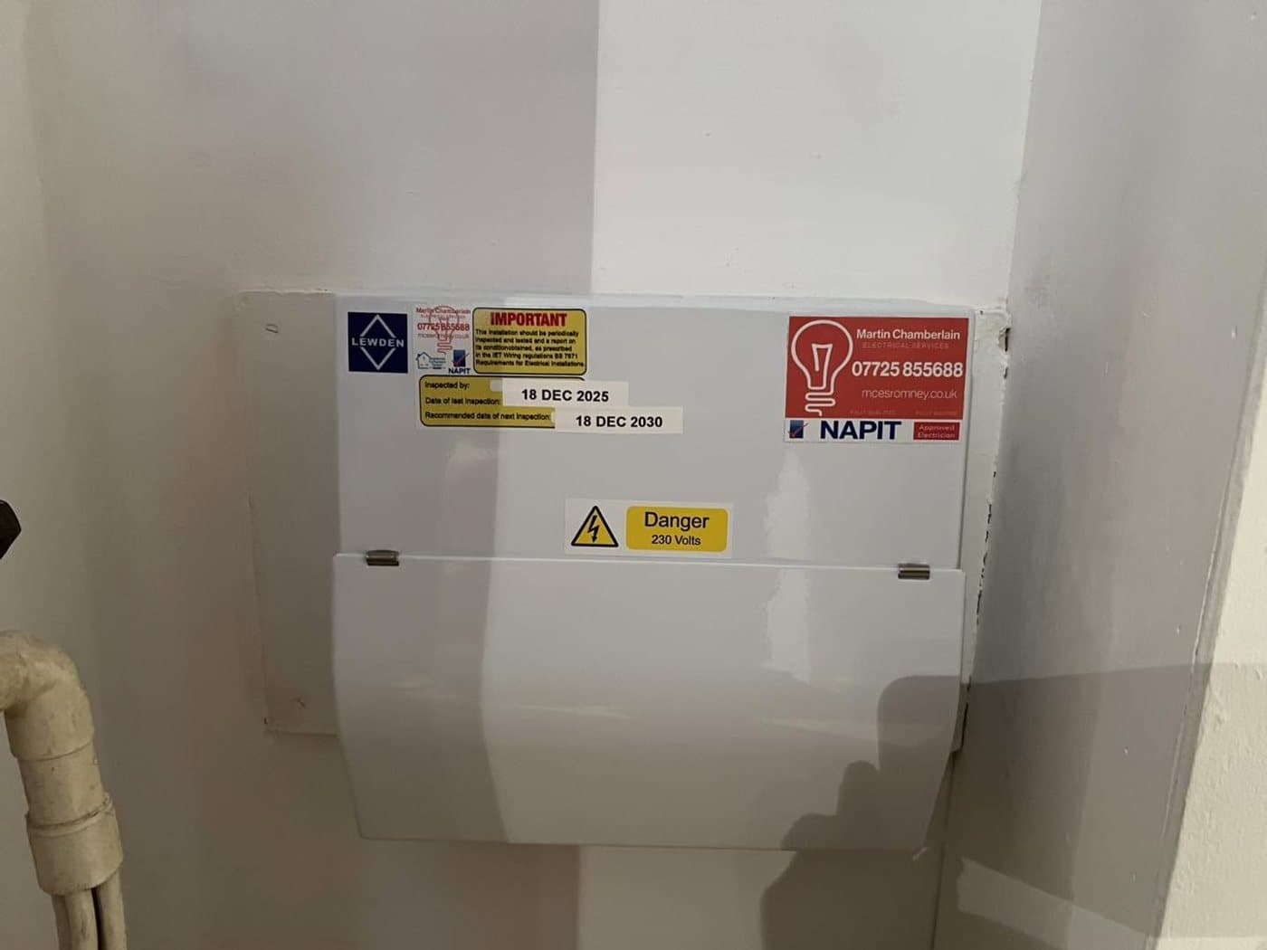 Newly fitted consumer unit with the certification and warning labels in place above the incoming supply