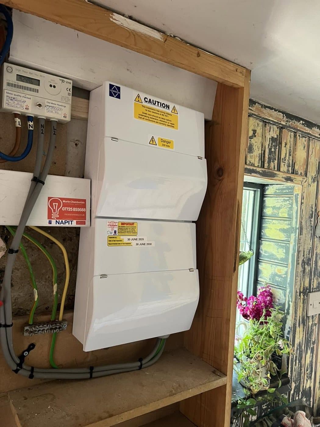 Consumer unit and meter neatly installed in a timber-framed garden room