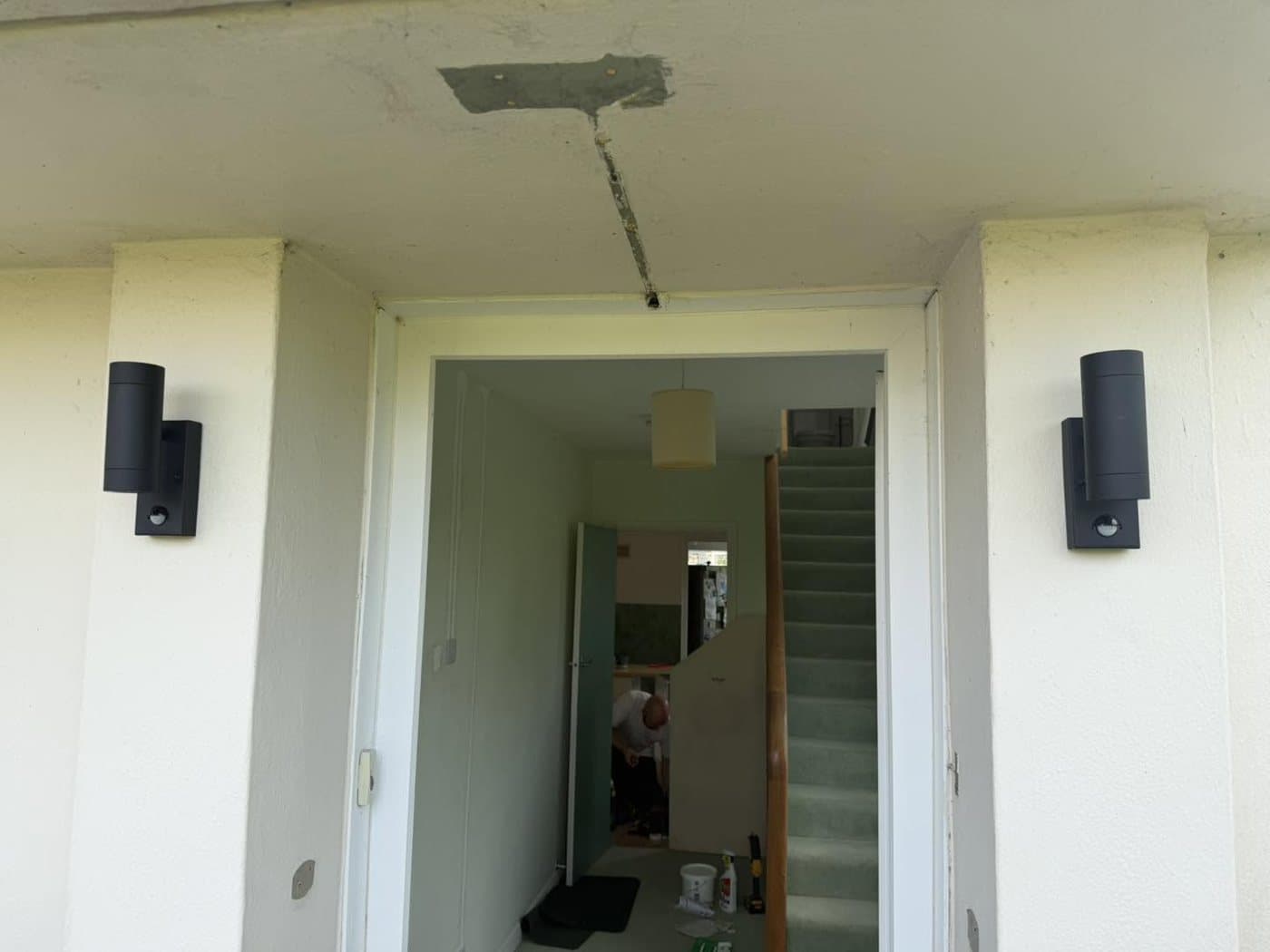 Up-and-down exterior wall lights fitted either side of an entrance doorway