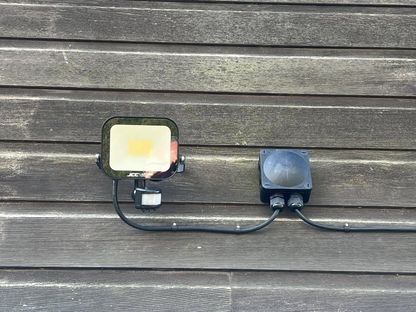 LED floodlight and weatherproof junction box fitted to a timber-clad wall