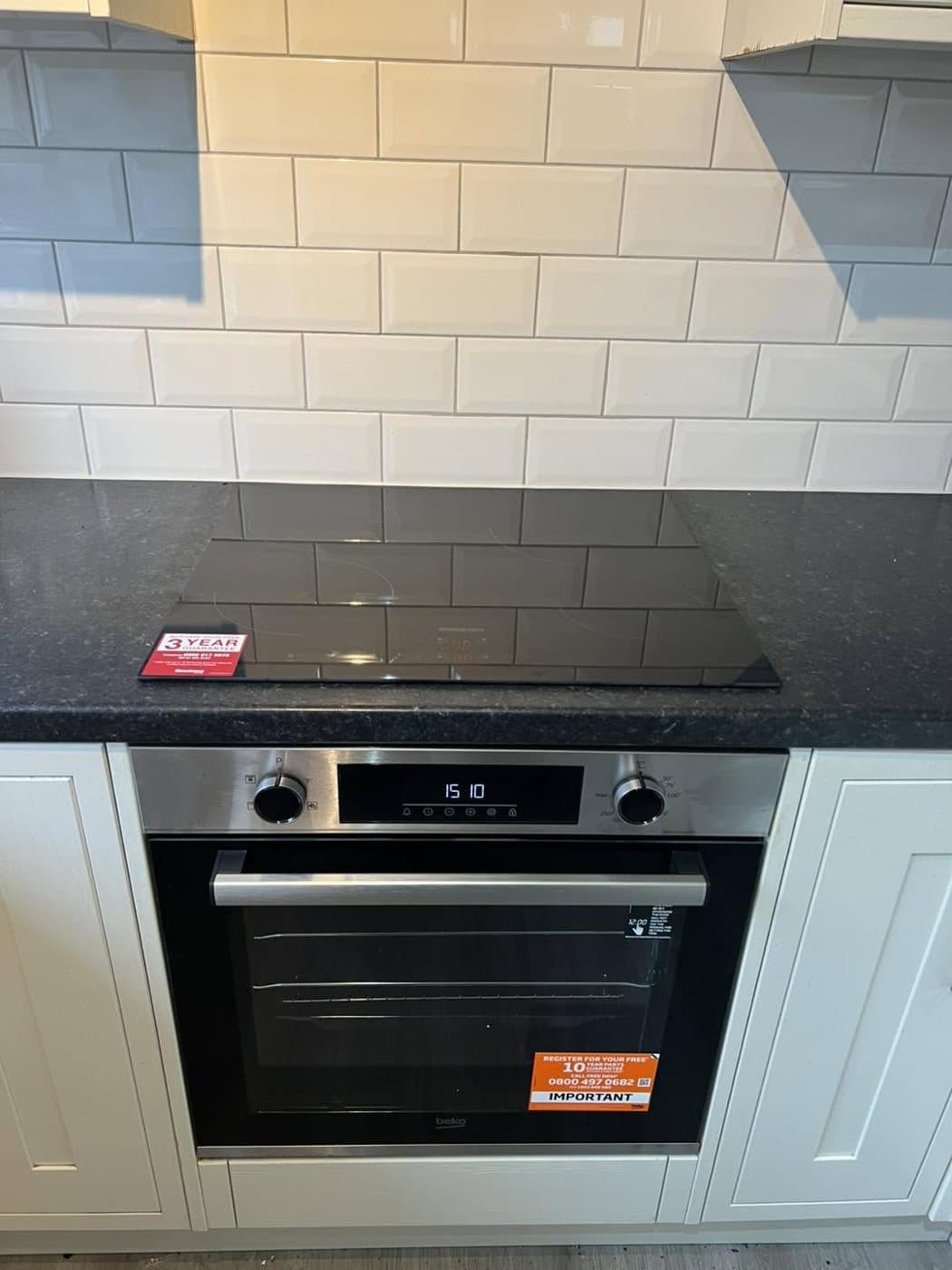 Built-in oven fitted under a tiled splashback in a modern kitchen