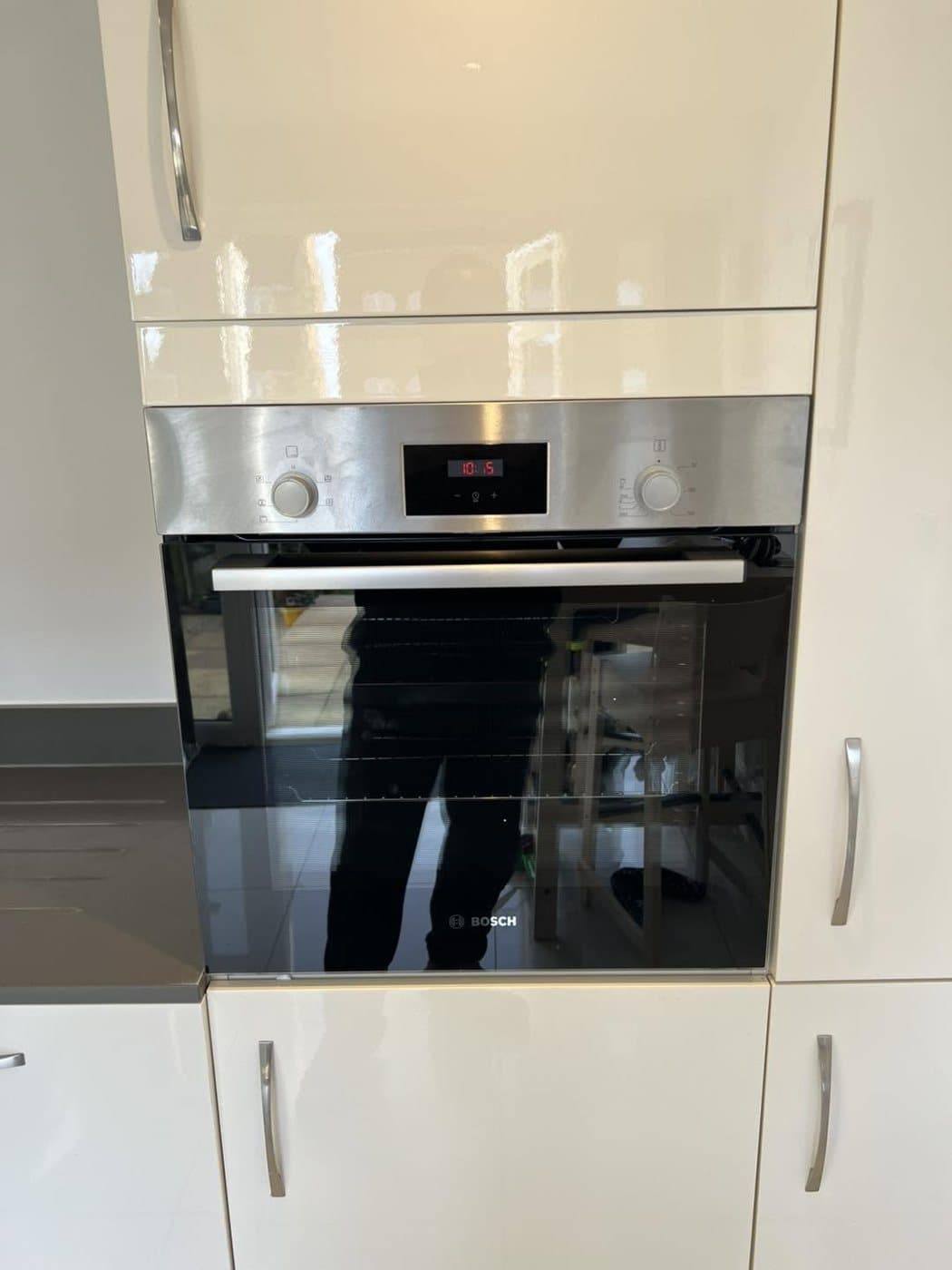 Built-in oven wired and fitted in a white gloss kitchen