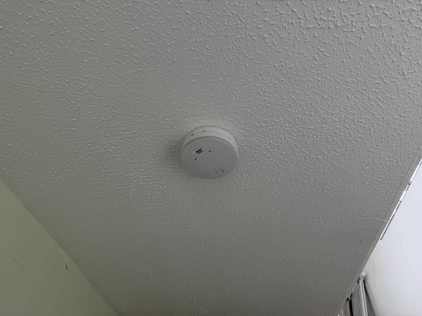 Mains-wired, interlinked smoke alarm neatly fitted to a ceiling