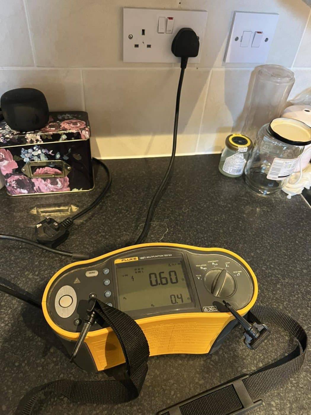 Calibrated electrical tester taking a reading during an inspection on a kitchen worktop